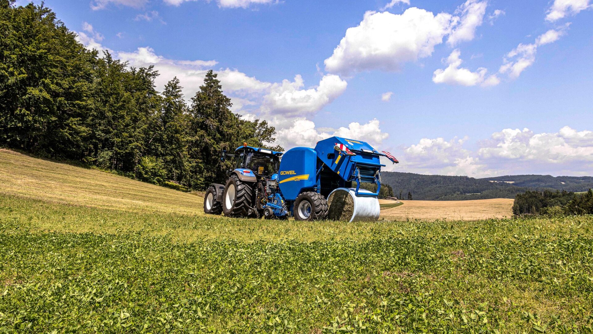 Wyrzut beli GÖWEIL G-1 F125 podczas wyrzutu beli sianokiszonki na łące