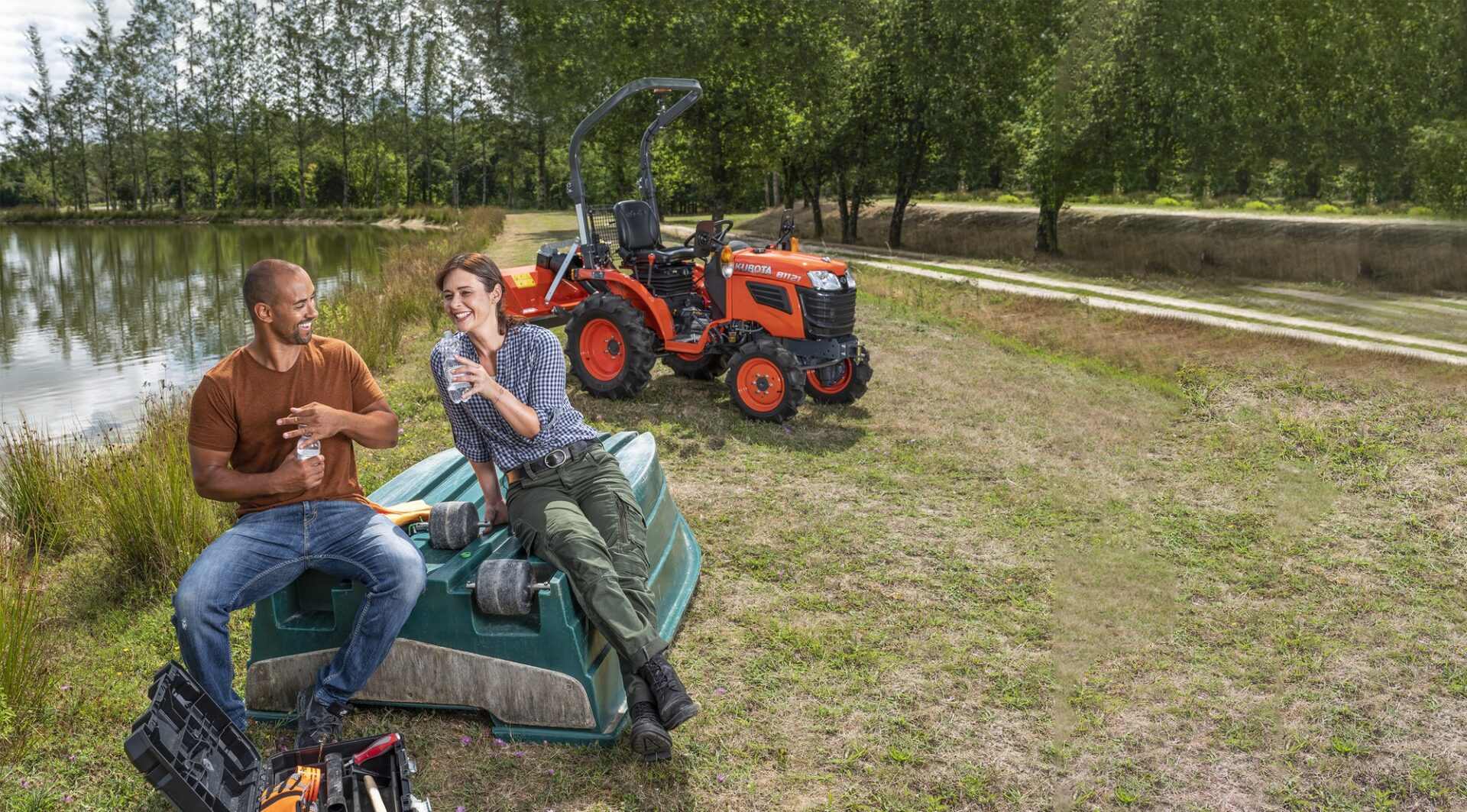 Kubota B1 – miniciągnik B1121 z tylną kosiarką bijakową na terenie zielonym nad stawem
