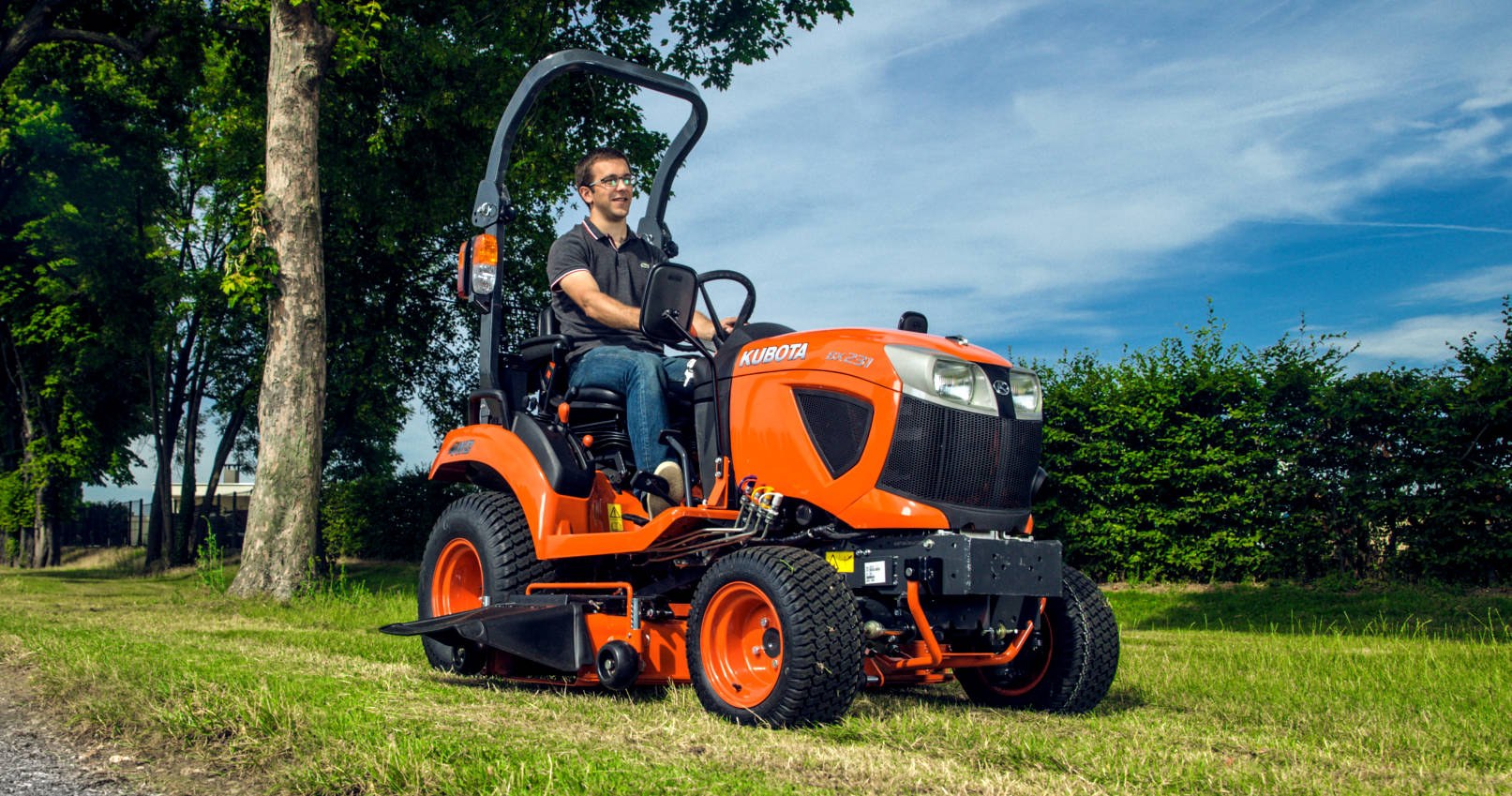 Kubota BX – miniciągnik z kosiarką międzyosiową podczas koszenia trawnika