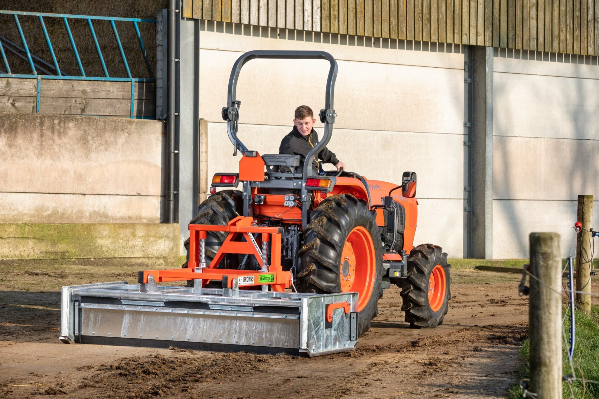 Kubota L1 – ciągnik kompaktowy L1-452 z równiarką przy budynku gospodarczym