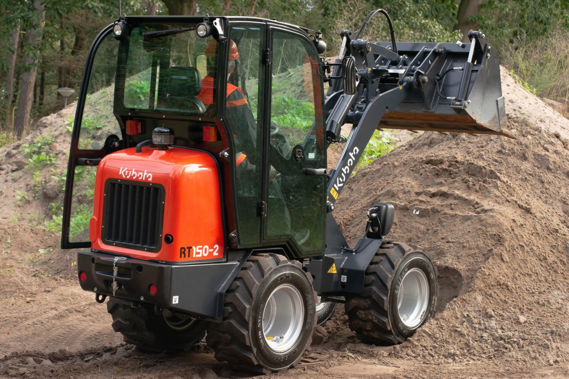 Kompaktowa ładowarka kołowa Kubota RT150-2 z kabiną przy pryzmie ziemi