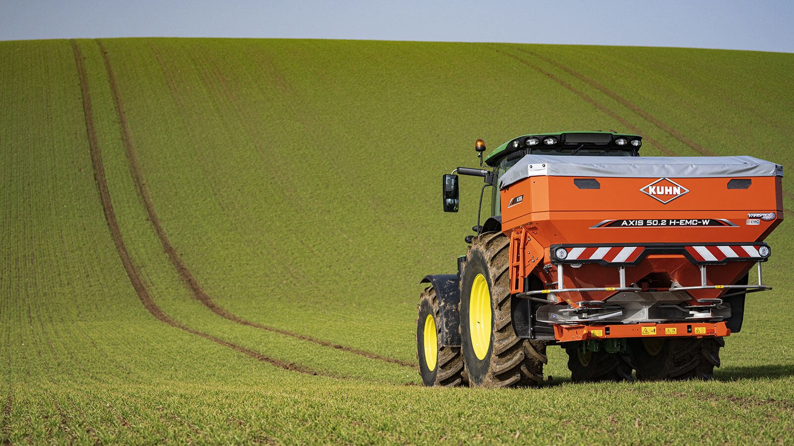 KUHN AXIS 50.2 w pracy Rozsiewacz nawozu KUHN AXIS 50.2 H-EMC-W podczas nawożenia zboża