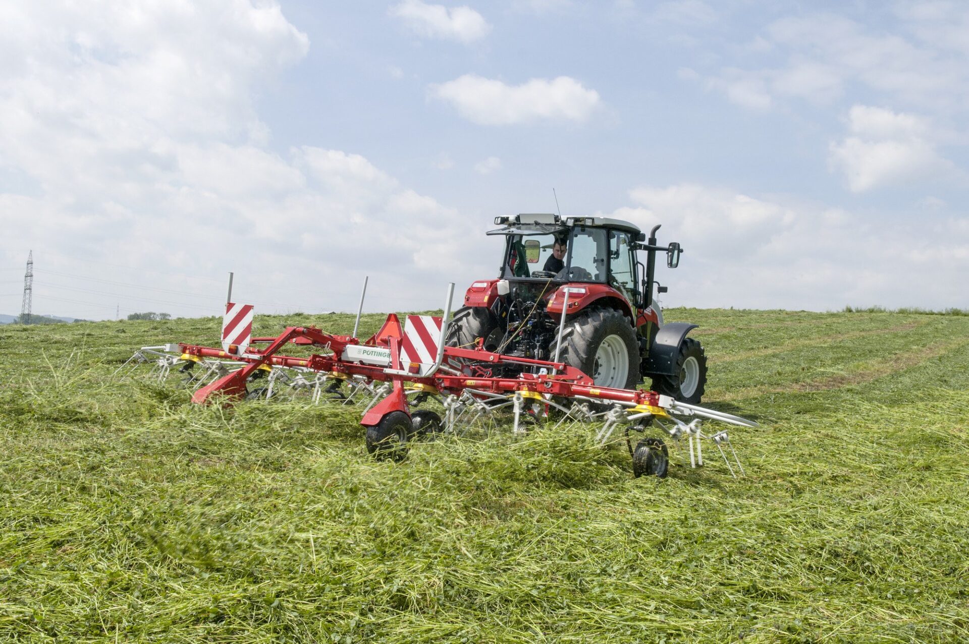 HIT 6.80 T na łące Sześciokaruzelowy przetrząsacz ciągany Pöttinger HIT 6.80 T na łące