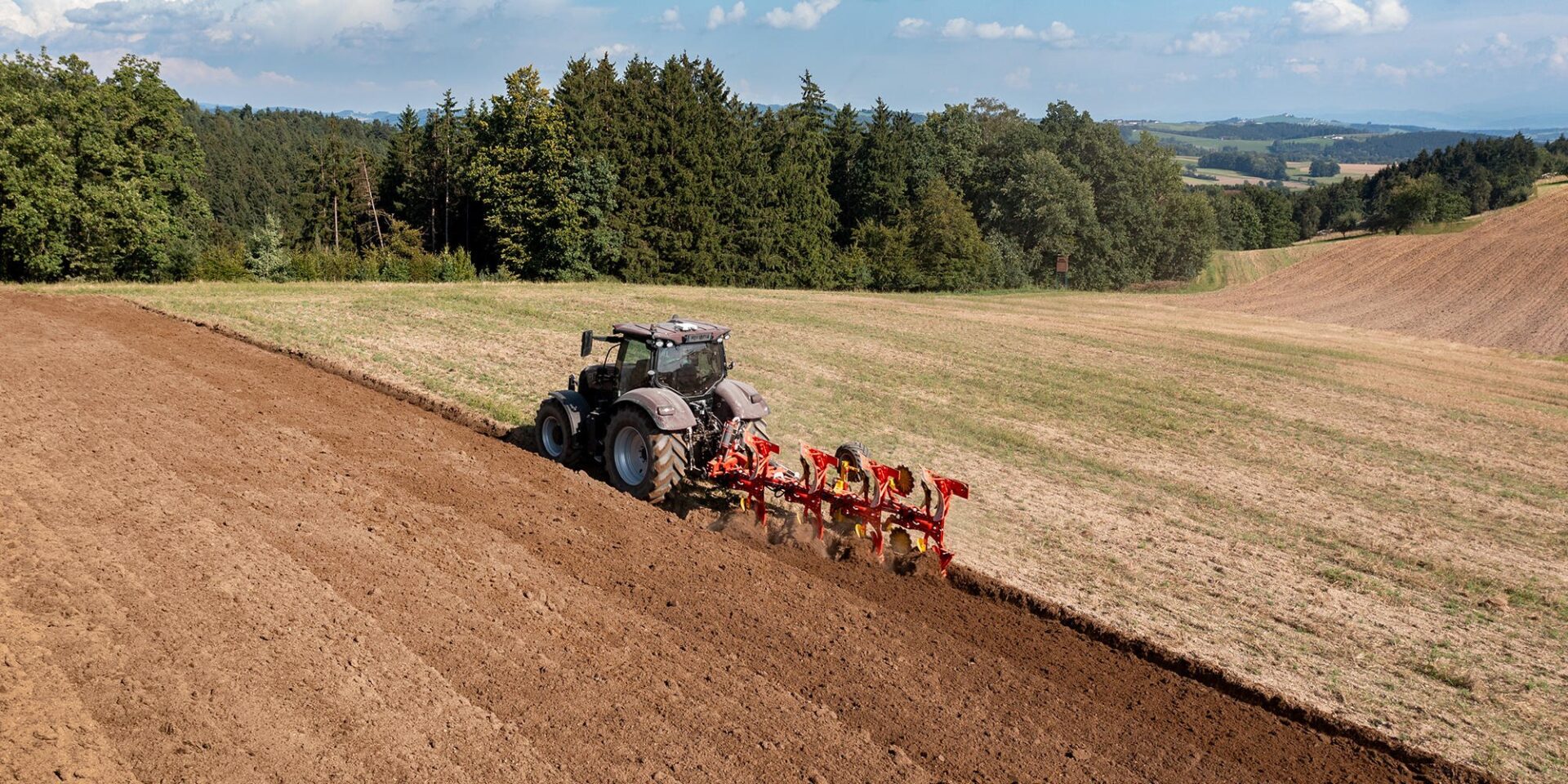 Pług obracalny Pöttinger SERVO 3000 z ciągnikiem podczas orki na stoku