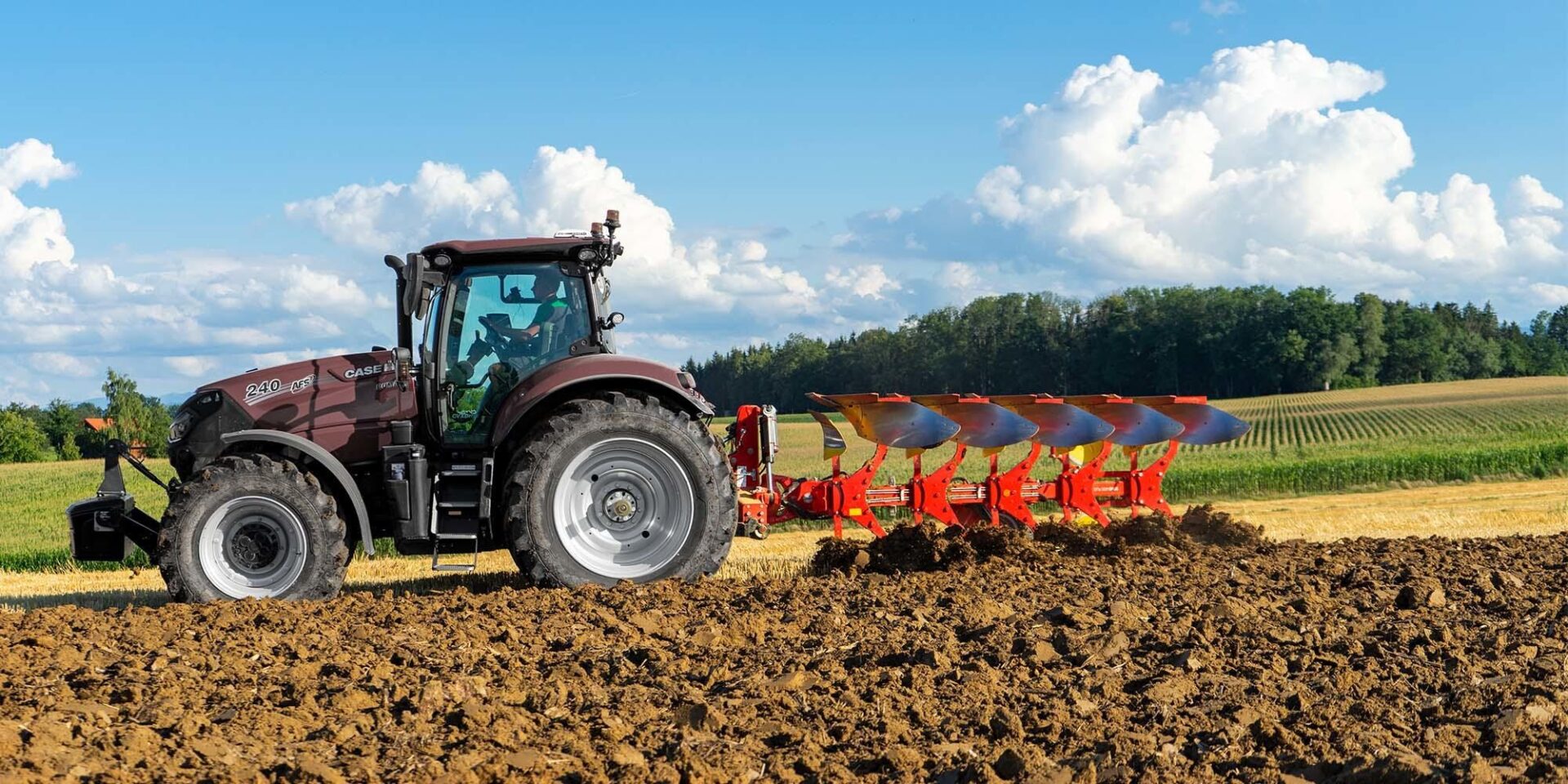 Pług obracalny Pöttinger SERVO 4000 z ciągnikiem podczas orki, widok z boku