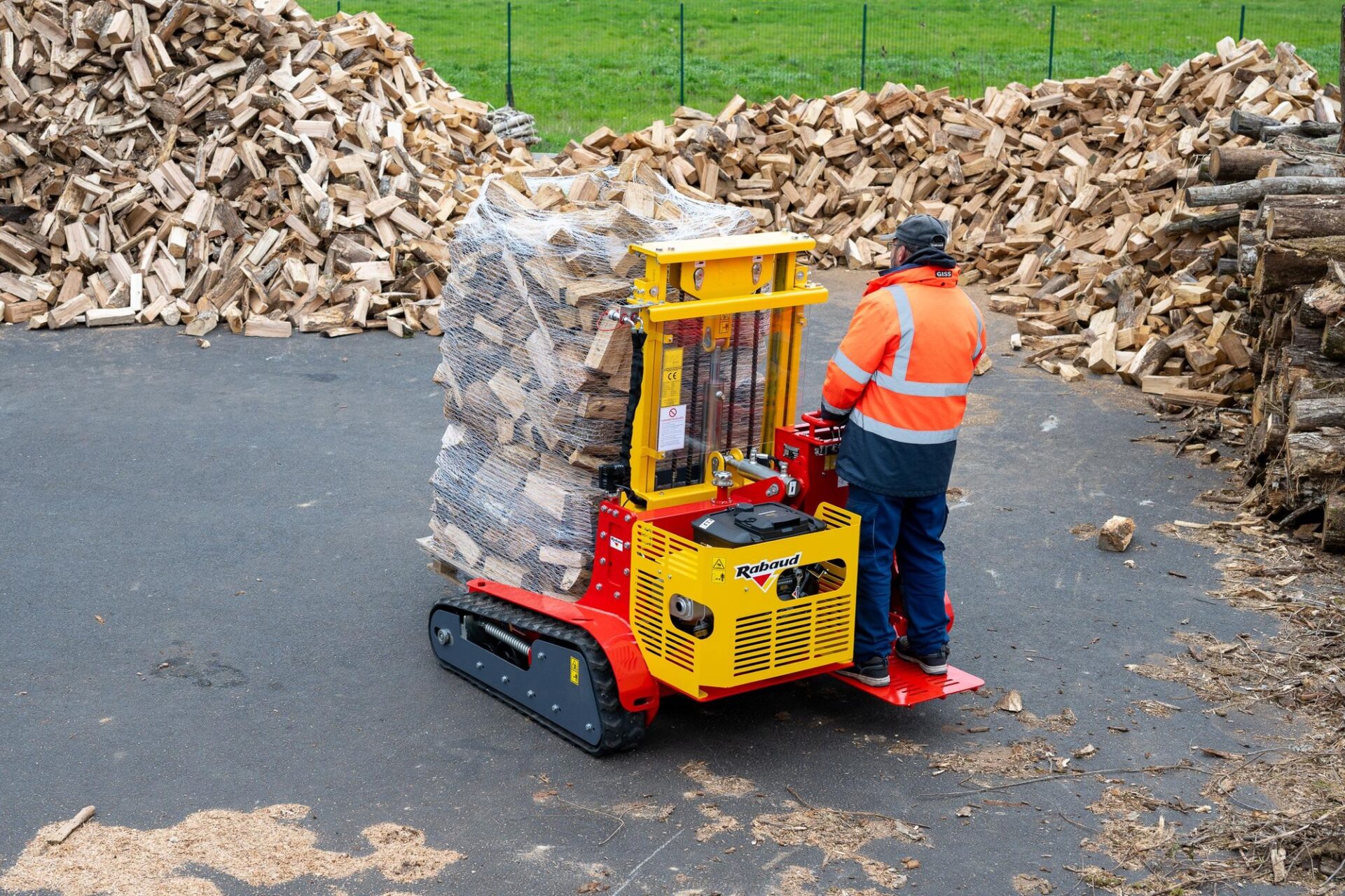 Gąsienicowy wózek paletowy Rabaud TRACKPALL 1800 przewożący paletę drewna opałowego